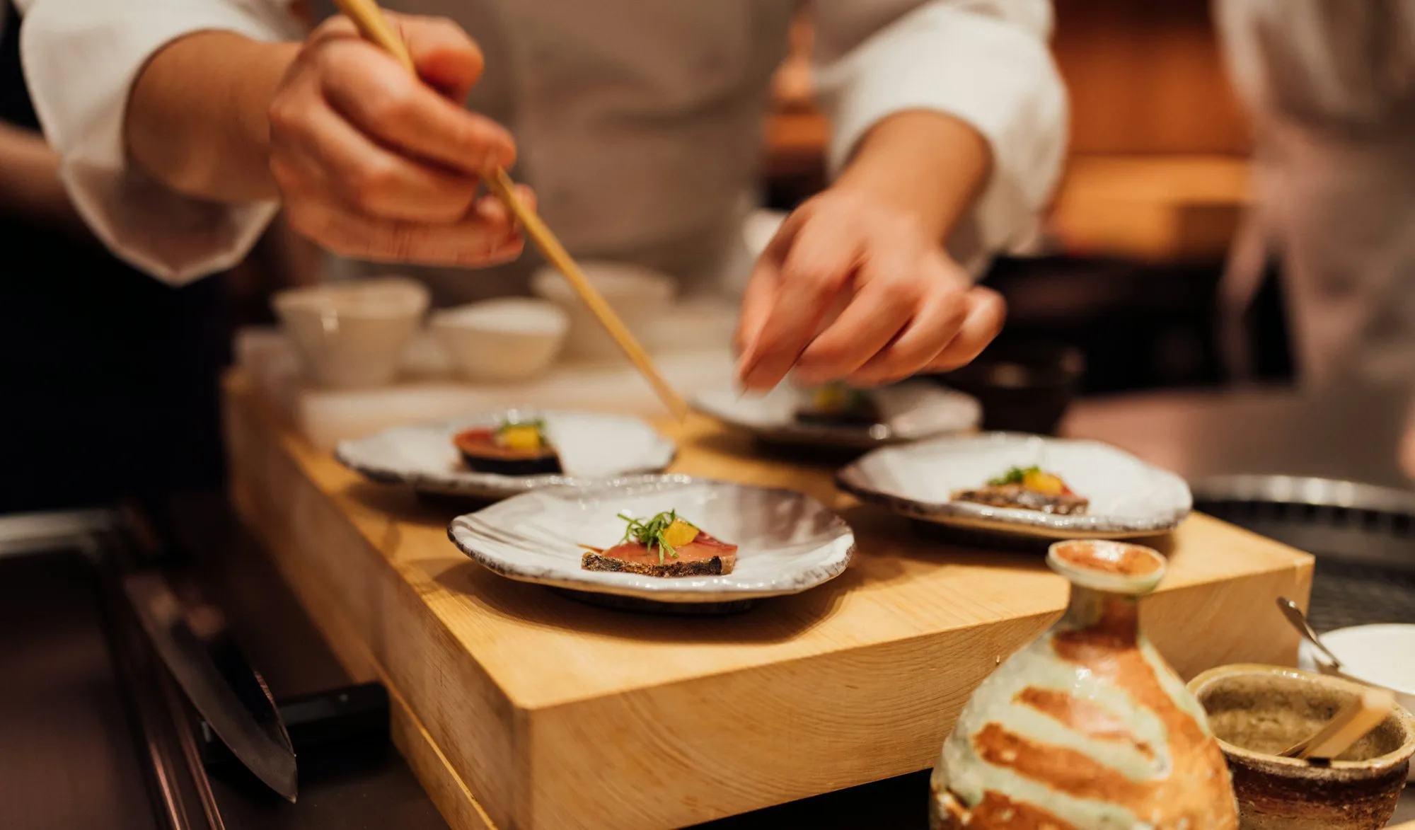 Chefs plating dishes at the pass