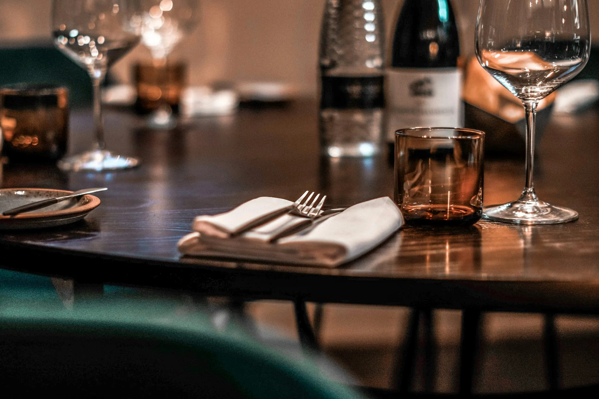 Table set with wine glasses in a dark dining room